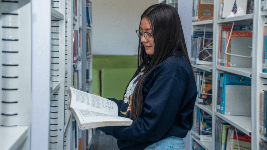 Student taking a book from a shelf