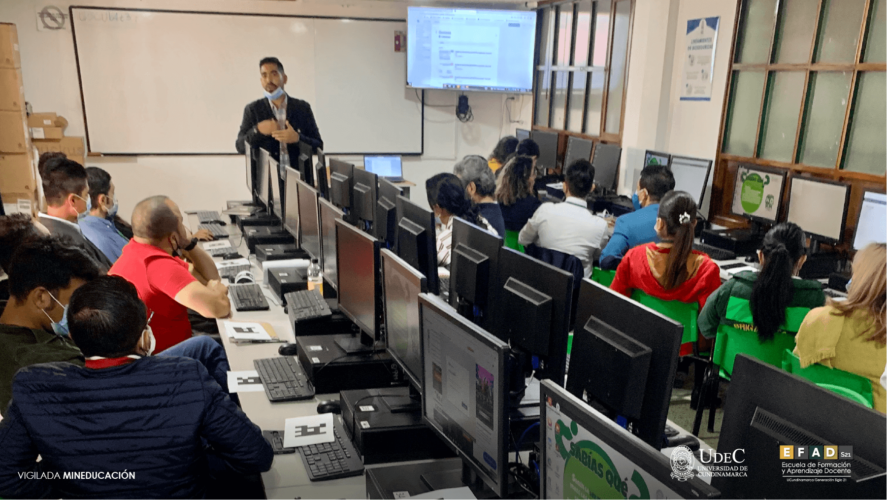 Profesor dictando una sesión de formación en una sala de sistemas