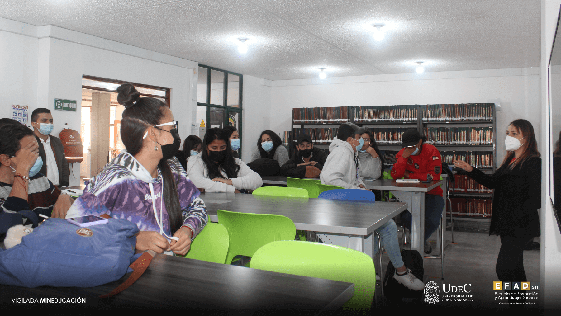 Grupo de profesores trabajando en las mesas de la biblioteca