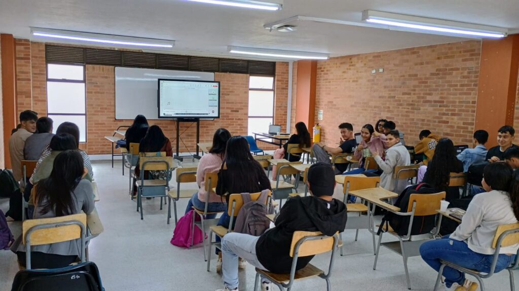 Aula llena de estudiantes de espaldas atendiendo a la pantalla durante la presentación de los Premios El Pensador IPA 2024.