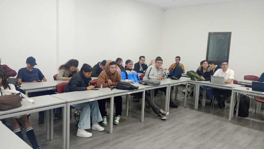 Estudiantes reunidos alrededor de las mesas de un salón conversando durante los Premios El Pensador IPA 2024.