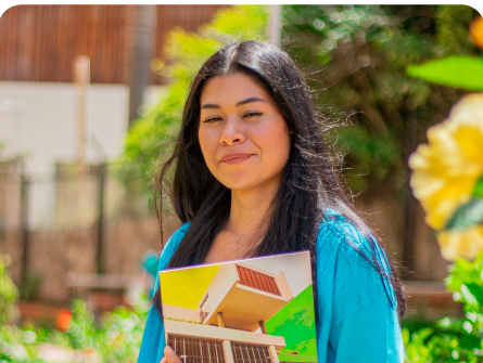 Estudiante de la sede Fusagasugá con una maqueta en la mano en una zona verde del campus