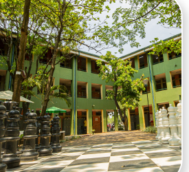 Patio interno de la sede Girardot con tablero de ajedrez gigante y zonas verdes