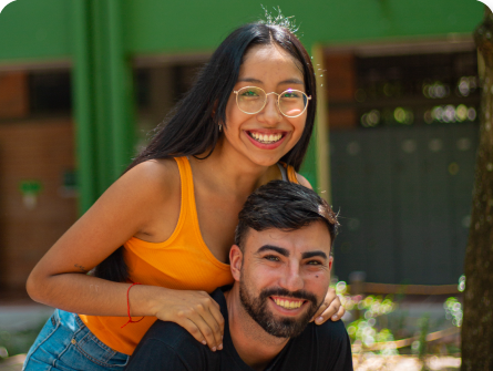 Dos estudiantes de la sede Girardot sonriendo en una zona verde del campus