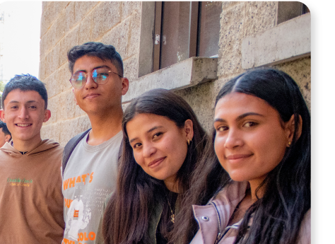 Grupo de cuatro estudiantes de la sede Ubaté sonriendo frente a la fachada del edificio